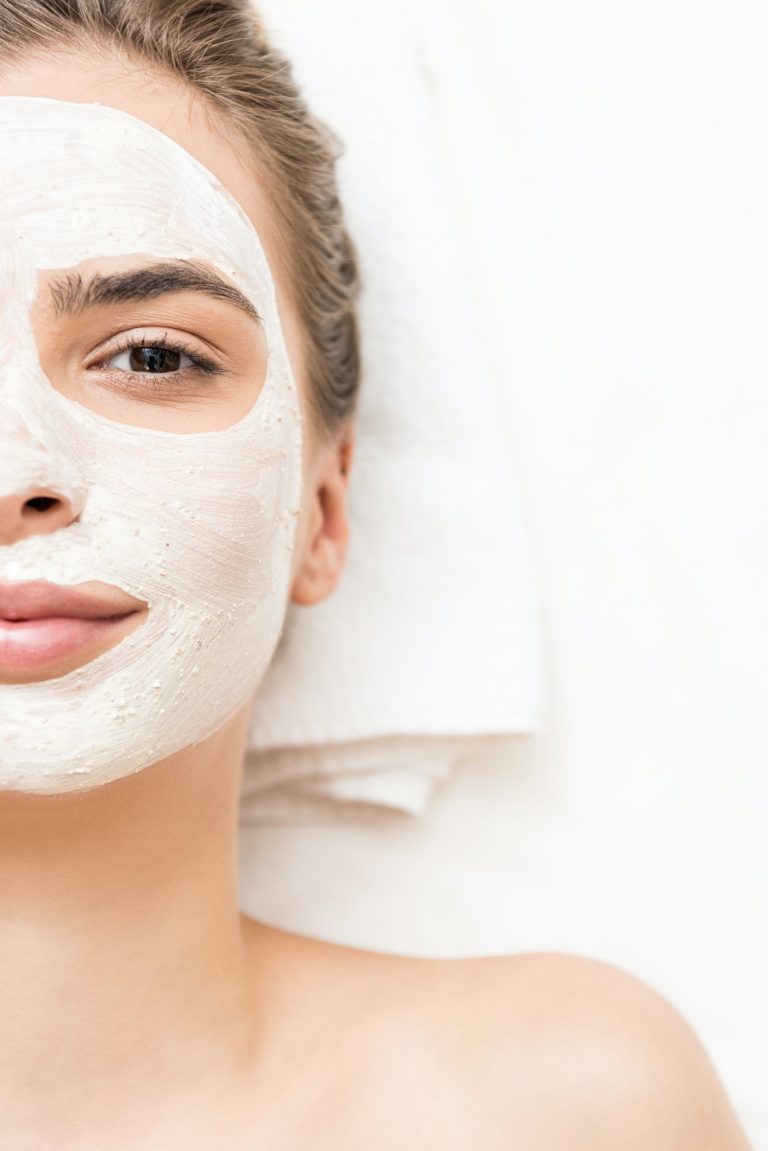 woman relaxing and receiving facial mask and spa therapy